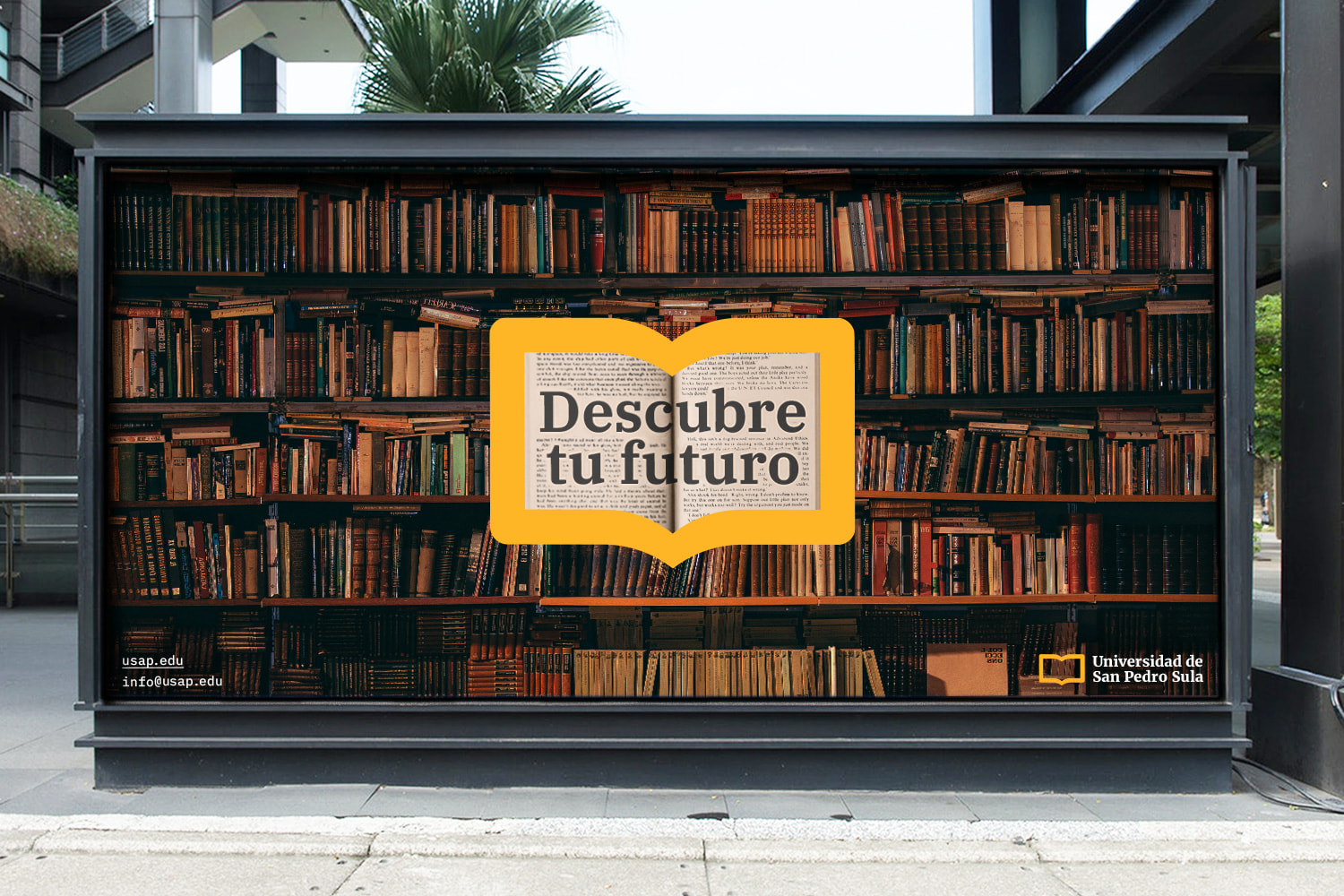 Street billboard for University of San Pedro Sula showing a bookshelf and the USAP logo as a window to an open book