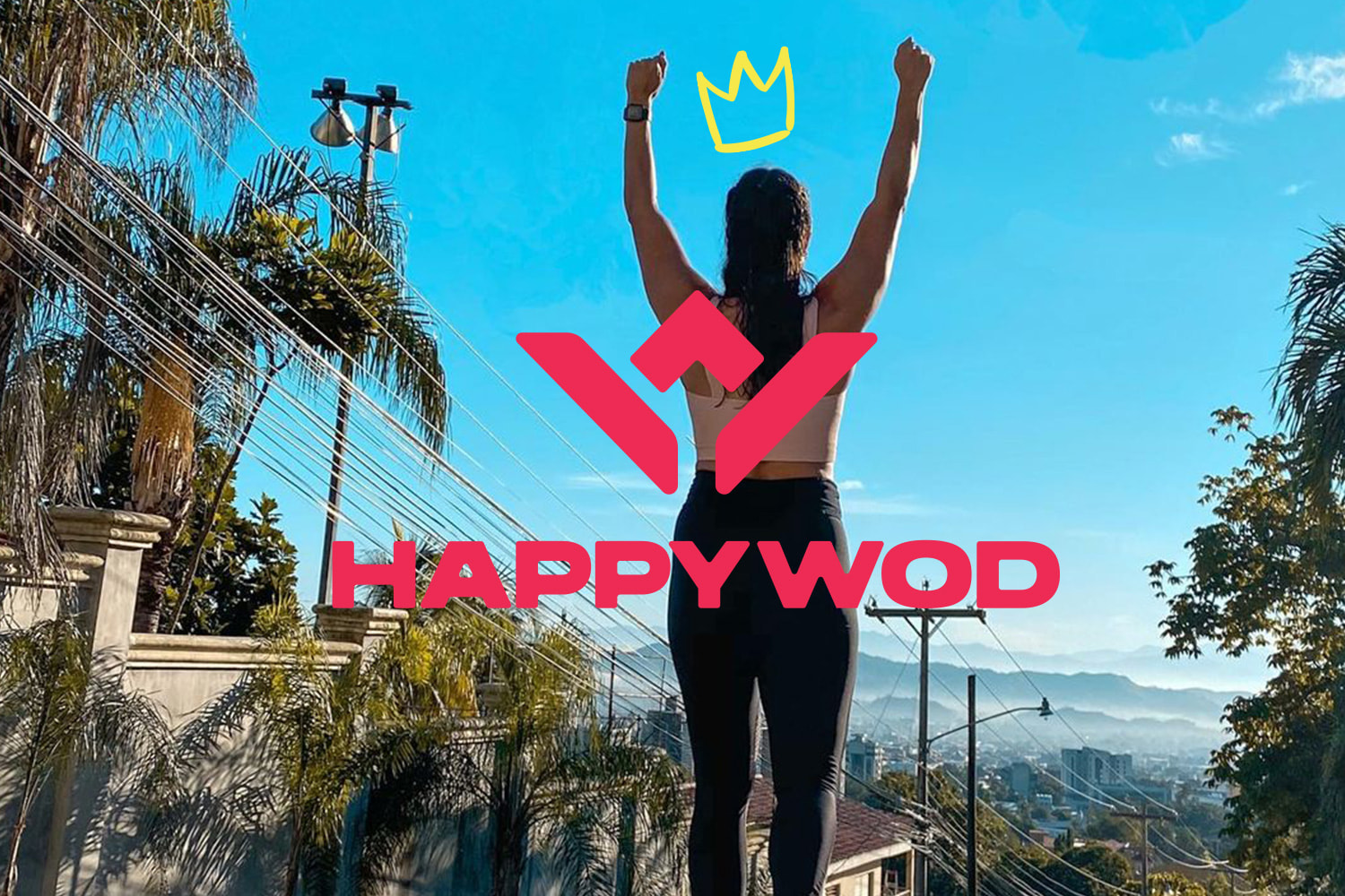 Woman raising arms claiming victory looking at the horizon with crown scribble above her head and HappyWOD logo over image